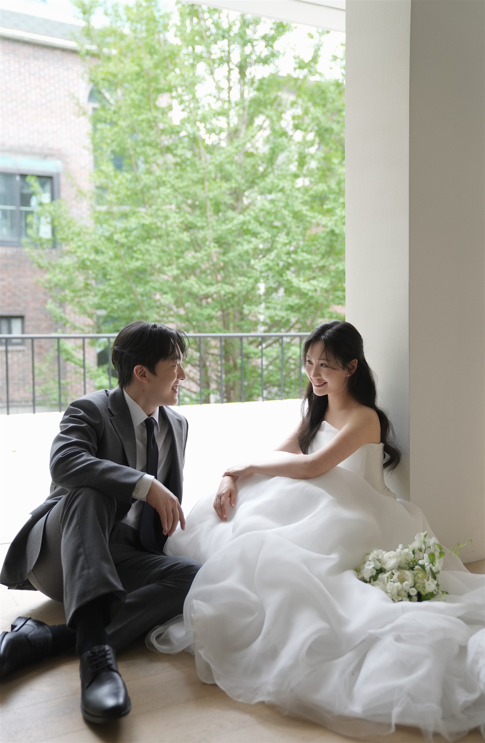 창가에 앉아 마주 보며 웃는 지현과 민하